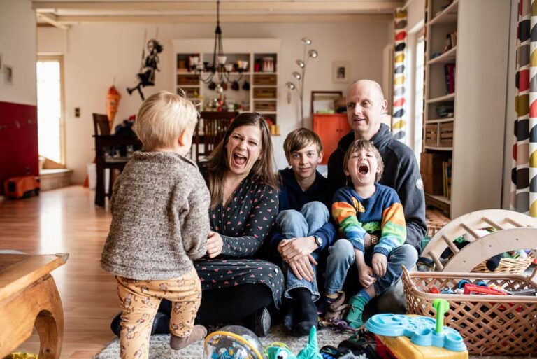 Familienaufnahme im Wohnzimmer auf dem Boden sitzend